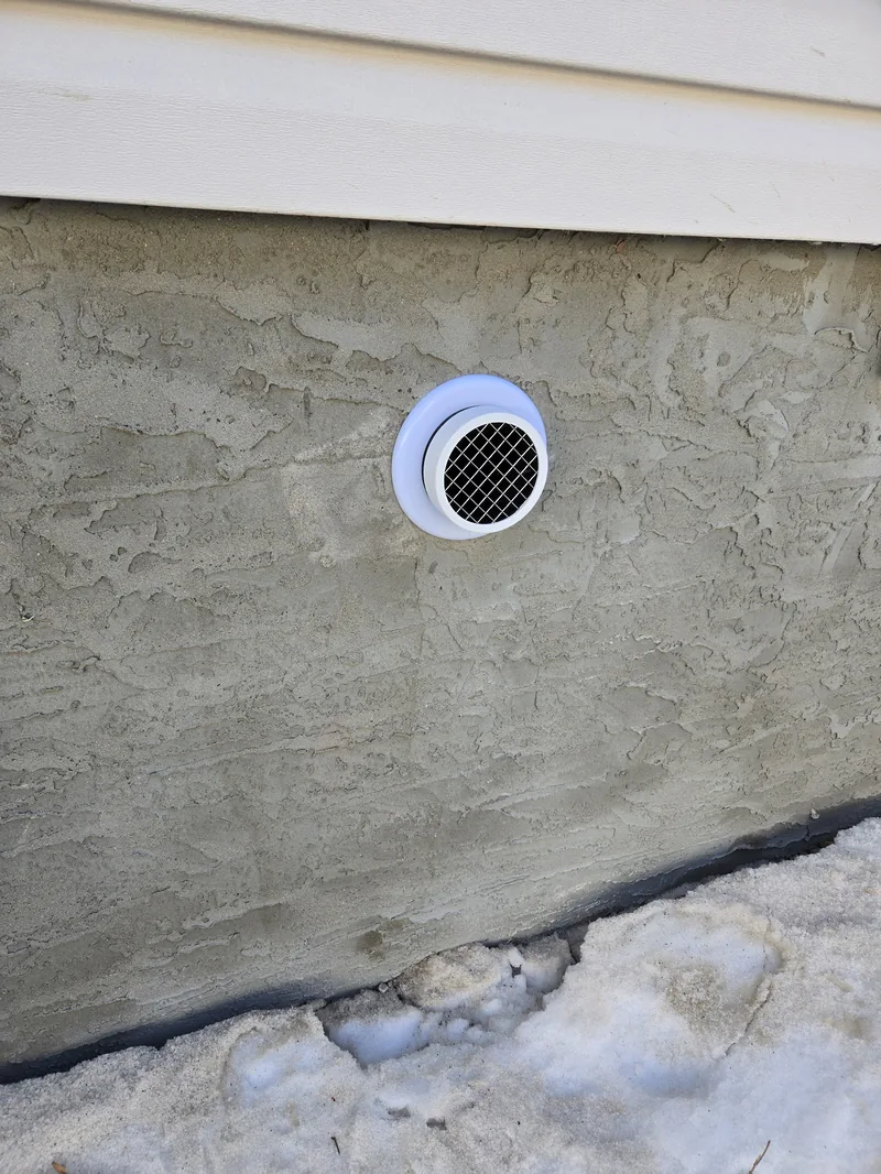 A neatly finished radon mitigation system in a basement