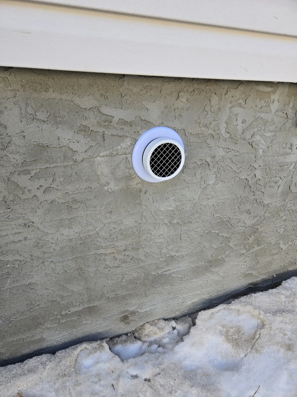 A neatly finished radon mitigation system installed by Sask Air Solutions